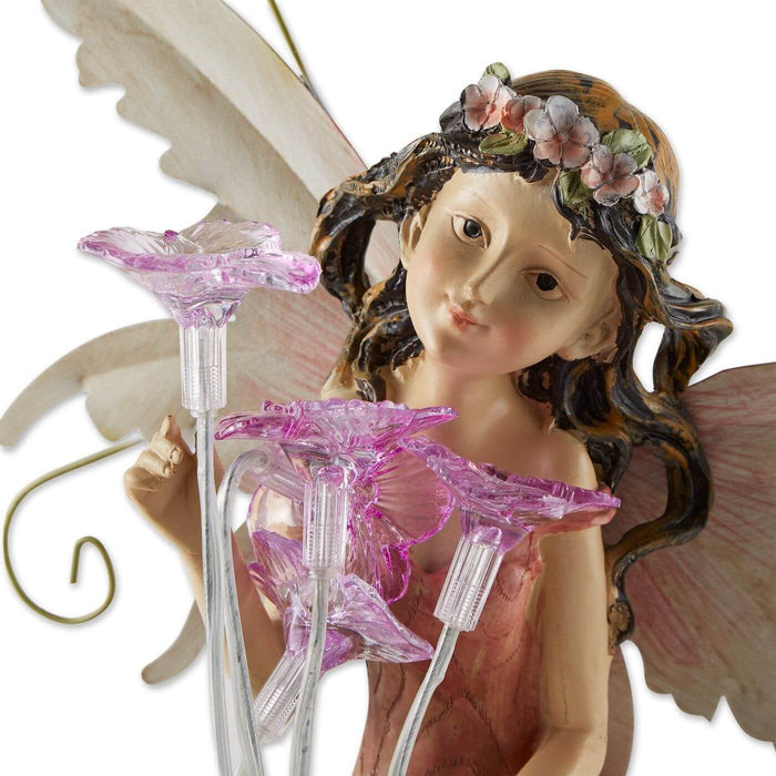 Detail of solar flower fairy statue showing the pixie's sweet face and the pink blossoms