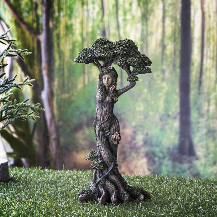 Greenswoman ent figurine with flowers and leaves posed in front of an enchanted forest backdrop