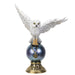 This awesome figurine features a white snowy owl. The bird of prey perches upon a shining dark orb, with a pentacle charm clutched in its talons. The nocturnal hunter's wings are spread, and the crystal ball beneath has a golden base with Celtic knot designs.