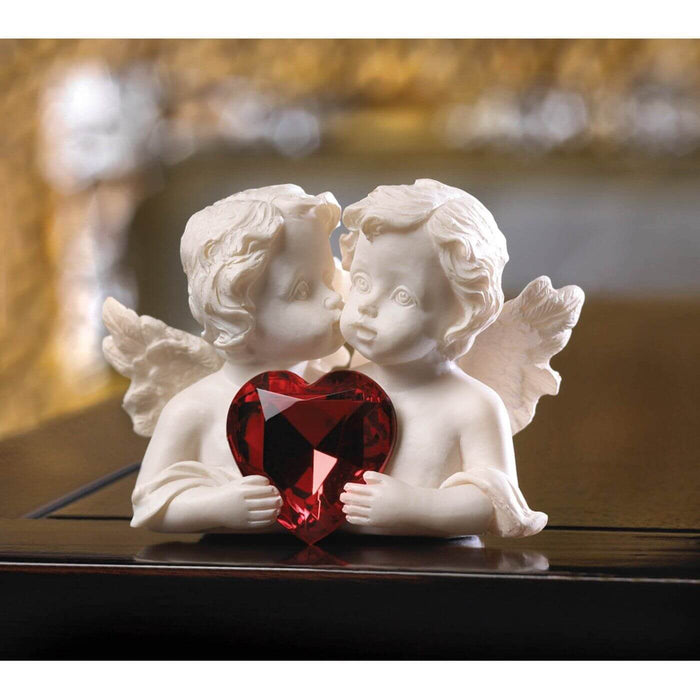 Cherub pair with red crystal heart displayed on a dark wood table