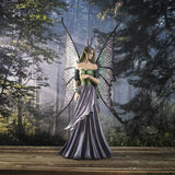 Large fairy figurine in shades of blue, purple, green and teal. Fairy has spotted wings, long hair and antlers. Shown in a forest setting