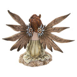 Steampunk fairy figurine with mechanical bronze wings and red hair. Goggles on her head and a striped outfit. She sits on a rock, gazing out. Shown from the back, spiral details on her wings