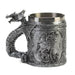 Silver-toned mug with scene of a dragon, and dragon handle. Stainless steel insert. Shown from the side, with sitting dragon and stars