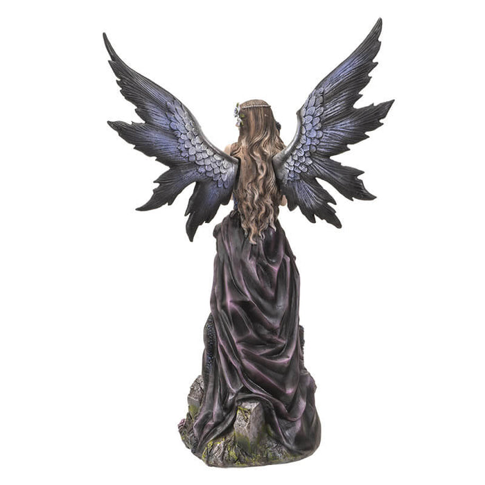 Back view of the fairy and crow figurine showing her purple and black wings spread out