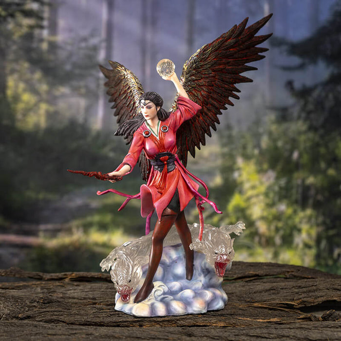 Sorceress in red dress with feathered wings. A sphere of air in one hand, wand in the other, and a pair of air elementals in the clouds at her feet. Shown against a forest backdrop
