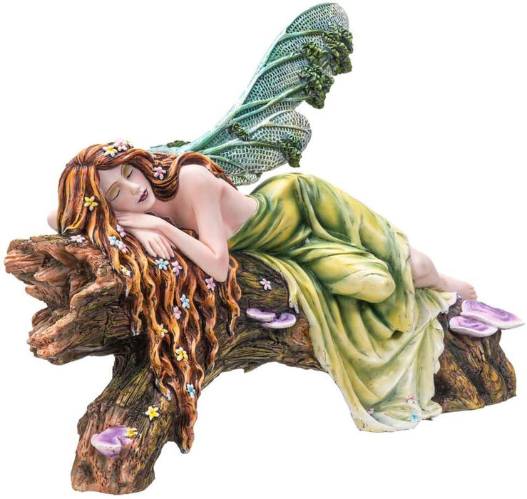 The statue features a lovely pixie sleeping on a forest log. The fae lady has a green dress and leafy emerald dragonfly wings to match. Her red-brown hair is adorned with colorful flower blossoms, and purple mushrooms sprout from the wood she slumbers on.
