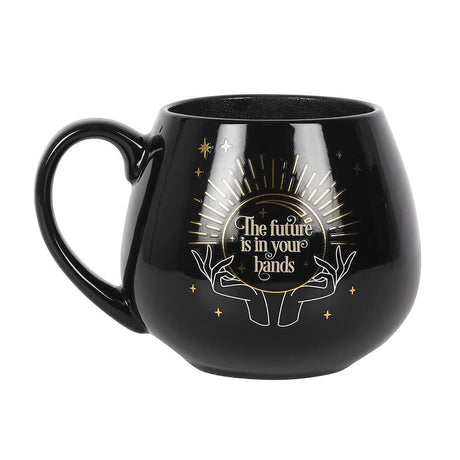 Fortune Teller Color Change mug. Black base with hands and a crystal ball. The words "The future is in your hands" are revealed when a hot beverage is poured in