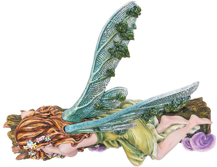 The statue features a lovely pixie sleeping on a forest log. The fae lady has a green dress and leafy emerald dragonfly wings to match. Her red-brown hair is adorned with colorful flower blossoms, and purple mushrooms sprout from the wood she slumbers on. Top down view