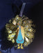 Brass peacock ornament iwth painted feathers in shades of teal, green, and gold