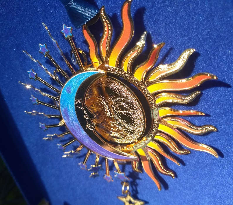 Side view of sun and moon ornament showing 3D layered metal