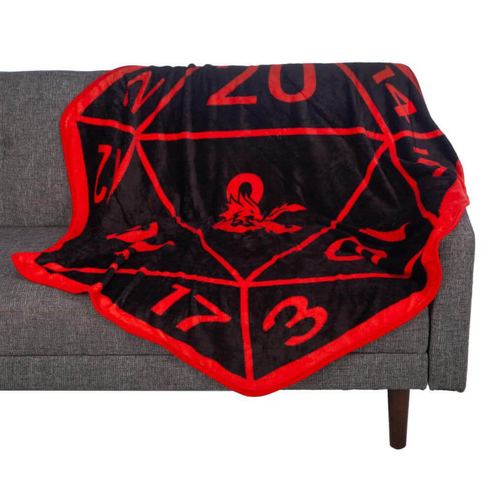 Red and black D20 dice shaped throw blanket with the Dungeons & Dragons logo, draped over a couch