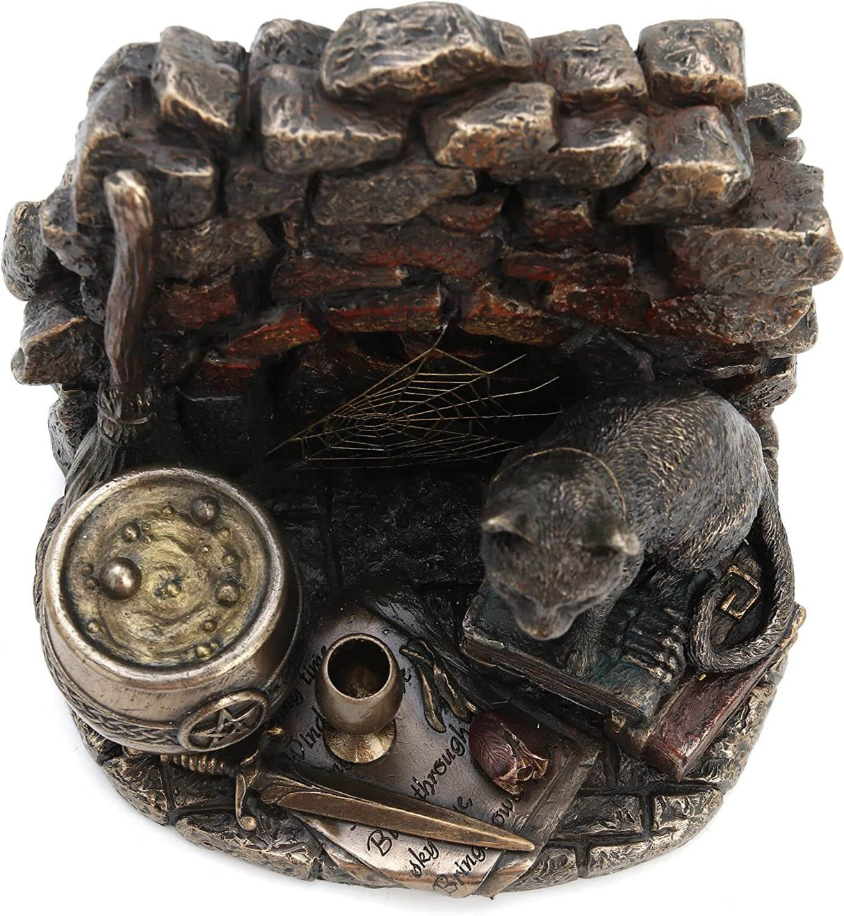 A cat wearing a pentacle sits upon a stack of thick leather-bound books. Next to the feline is a broom and bubbling cauldron, spiderweb, chalice, and athame dagger with a rose. A brick backdrop completes the piece. View from the top looking down into the chalice, showing papers under the vessel, rose and athame