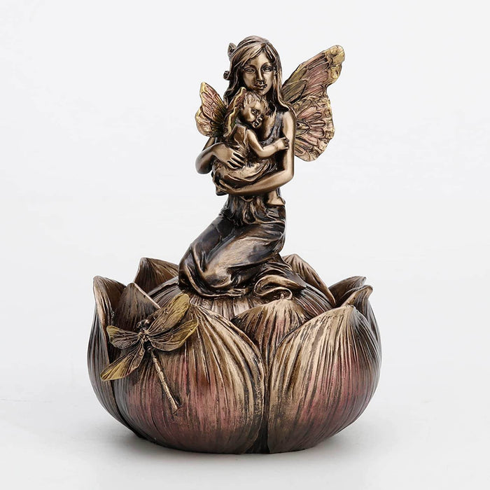 Trinket box in faux metal featuring a mother and baby fairy on a flower with a dragonfly. Shown closed
