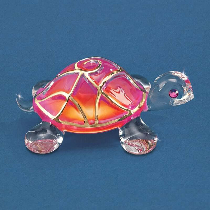 Glass Baron turtle made of clear glass with a pink orange shell ccented in real gold swirls with a pink crystal eye