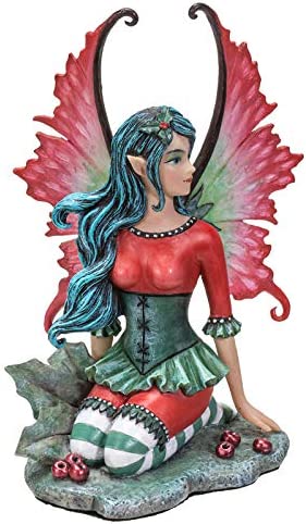 Fairy Figurine in red and green with holly leaves and berries, by artist Amy Brown. Front view, fairy is gazing to the side