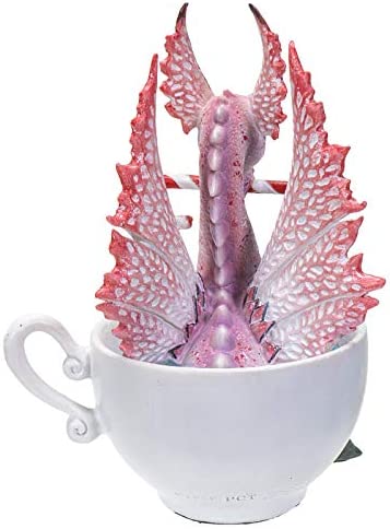 Pink and red dragon sitting in a cup, holding a candy cane in its mouth. Holly leaves and berries sit at the base of the cup. Back view of dragon wings with white patterns
