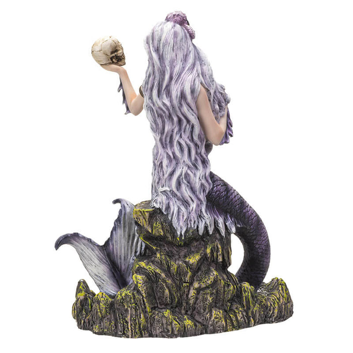 Mermaid holding up a skull figurine. Shown from the back, her hair is very long.
