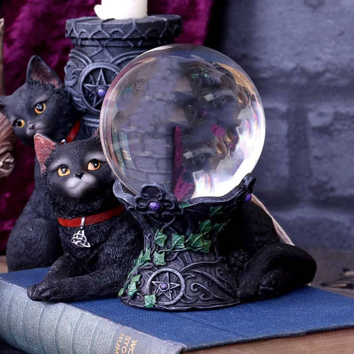 Black cat crystal ball holder shown on a book