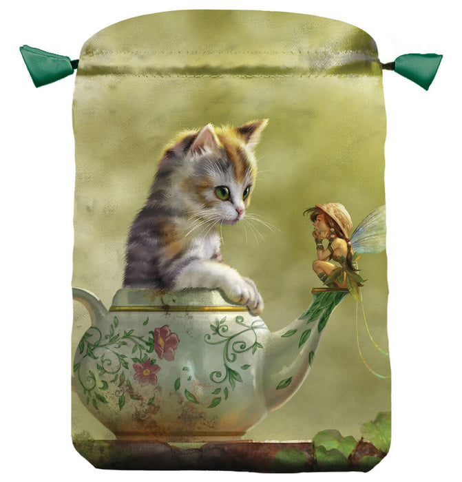 A decorative drawstring bag.  A calico kitten sits in a teapot, and on the spout sits a little fairy. The pixie has iridescent wings and a walnut shell hat, and the teapot shows a floral design with pink flowers. 