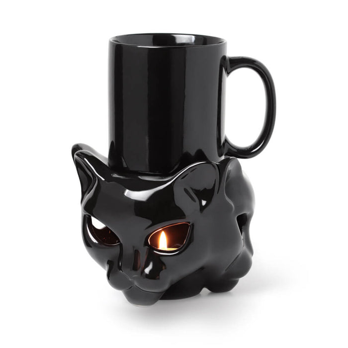 Ceramic glossy black cat mug holder with a tealight inside, warming a black coffee mug