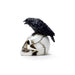 Miniature figurine of a black raven on a white human skull
