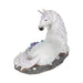 White unicorn with jewels in mane and tail laying down near blue-purple crystals. View showing hindquarters with blue swirl designs