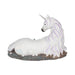 White unicorn with jewels in mane and tail laying down near blue-purple crystals, back view