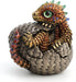 Baby dragon hatching from egg, done in shades of gold and red with blue and yellow accents and a green eye