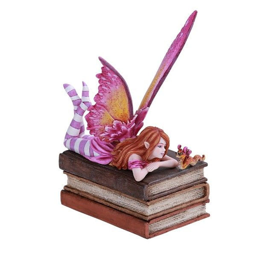 A fairy with red hair and a pink dress and wings lays on a stack of three books with a bookworm companion