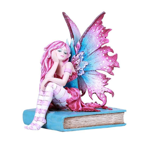 A fairy with pink and blue wings and an outfit to match sits on a cyan book