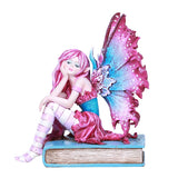 A fairy with pink and blue wings and an outfit to match sits on a cyan book