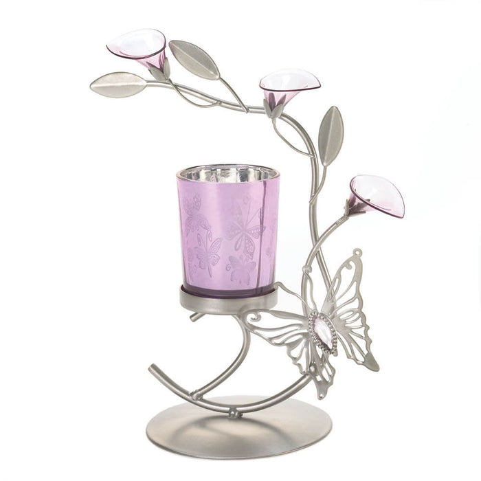 Candleholder with a metal  butterfly and lily blossoms curving above a pale purple candle holder with butterfly designs