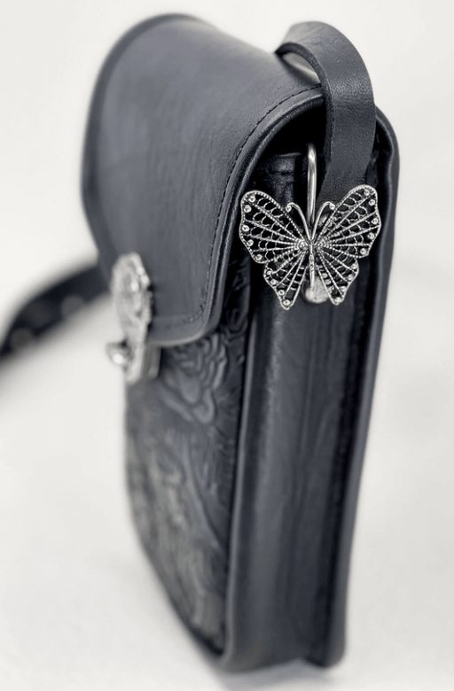 Butterfly key holder purse hook shown on a black leather bag