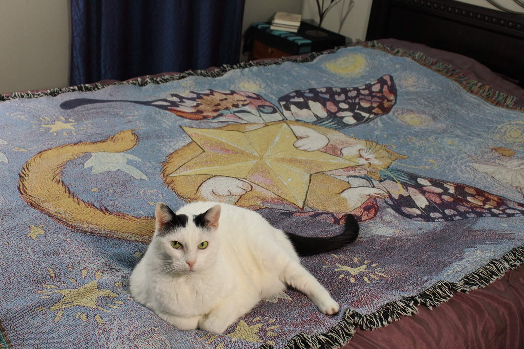 Starry Butterfly Cat Tapestry Blanket being sat upon by a white and black cat