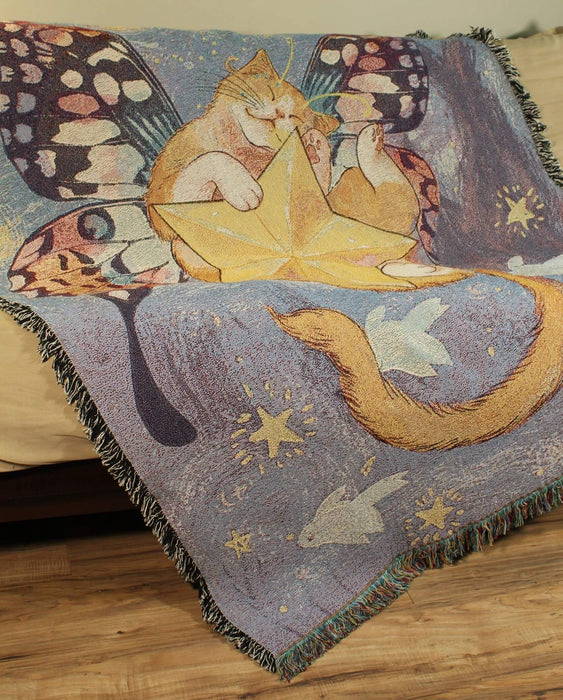 Starry Cat tapestry blanket shown draped upon a couch