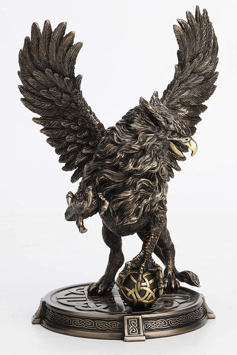 Griffon figurine - wings spread and rearing up with one claw on a Celtic knotwork sphere. With more Celtic knot designs on the base. Front view