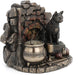 A cat wearing a pentacle sits upon a stack of thick leather-bound books. Next to the feline is a broom and bubbling cauldron, spiderweb, chalice, and athame dagger with a rose. A brick backdrop completes the piece. View from the left, better showing broom and cauldron