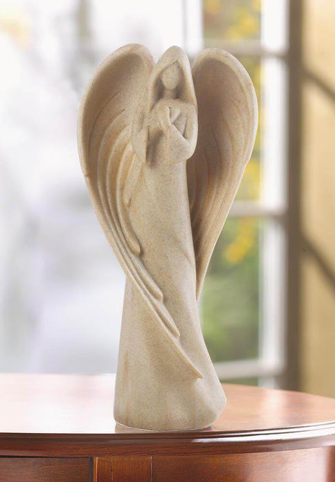 Angel figurine in soft sand color displayed on a wooden table