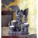 Stone-finish candleholder featuring a dragon curled around a castle with three spots for candles. Shown with lit white candles on a wooden table.