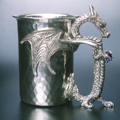 hammered pewter stein with dragon wings wrapped around stein and dragon holding gems as handle