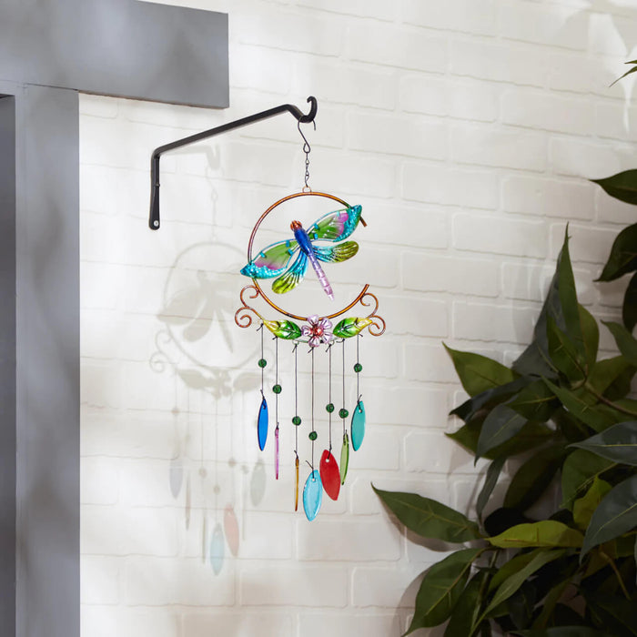 Dragonfly wind chime hanging against a white wall