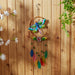 Dragonfly windchime shown against a wood fence