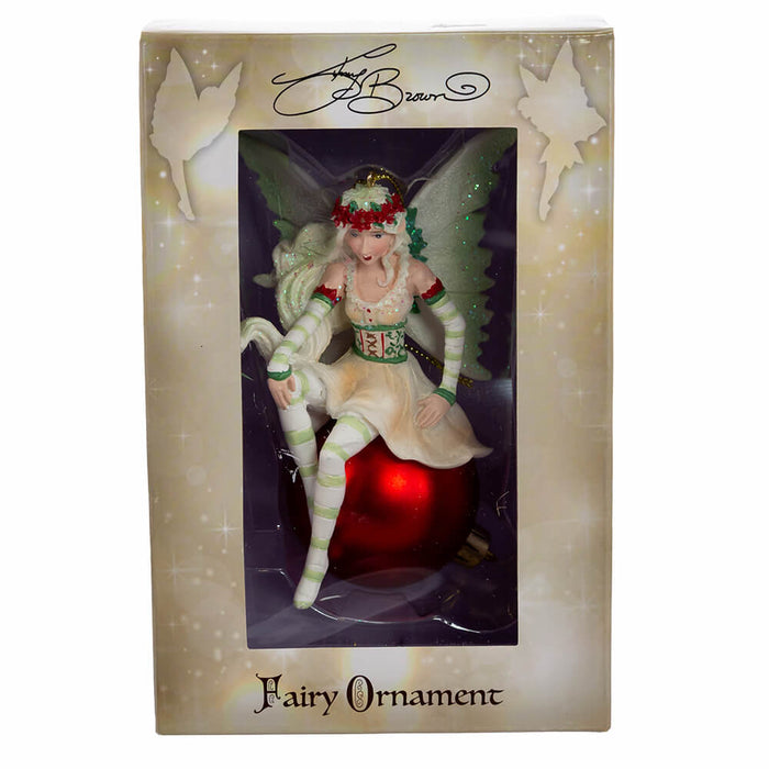 Amy Brown fairy ornament in shades of green and white, with pixie sitting on a red ornament ball. Shown in window box