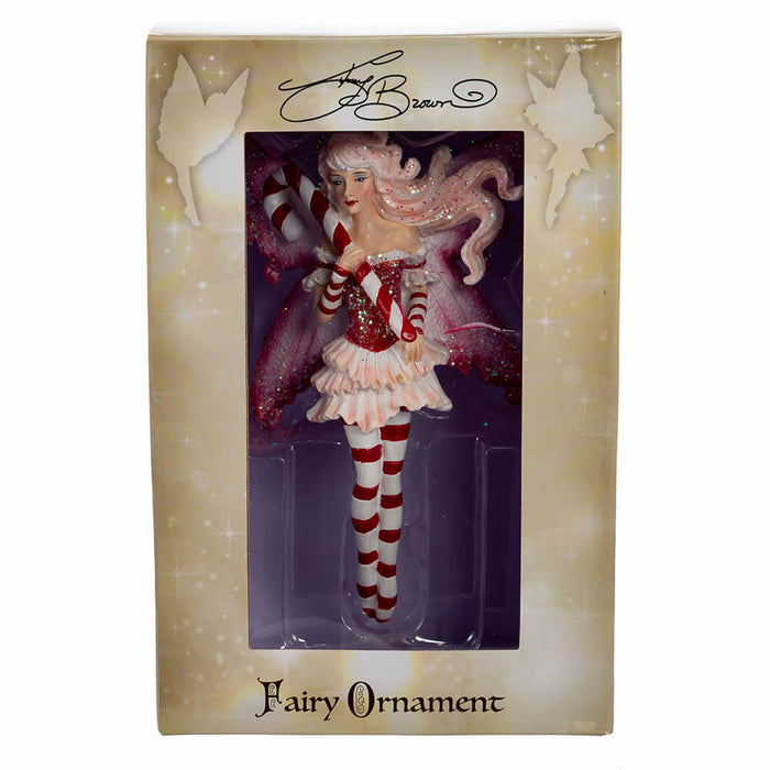 Amy Brown Fairy ornament in red, pink, and white, holding a candy cane. Shown in window box