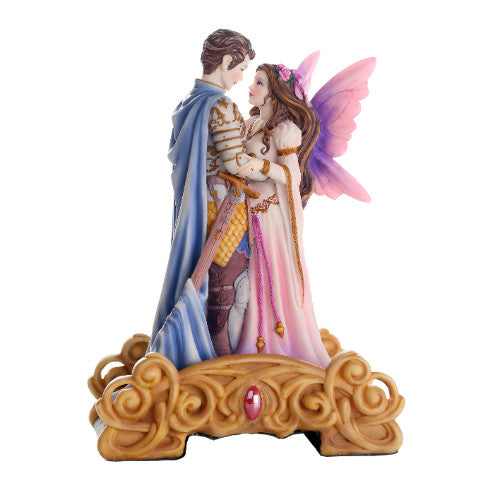 Figurine featuring two fairies gazing into each other's eyes, standing on an ornate bridge. The lady wears pink with pink and purple wings, and the man is dressed as a knight with a sword and blue cape.