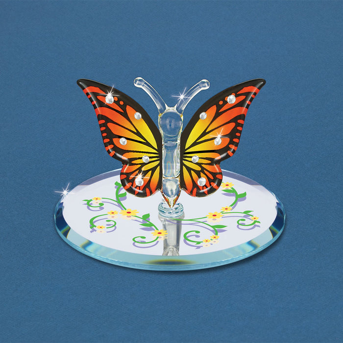 Orange and yellow monarch butterfly on a mirror base decorated with flower vines in yellow and green