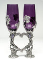 purple colored glass wine flutes with pewter grape vine wrapped around and positioned to form a heart.