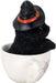 Black kitten in a white teacup. Cat wears a witch hat. Side view