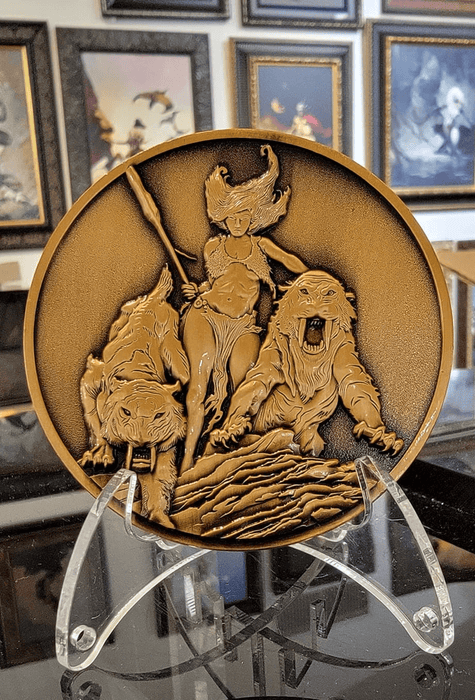 Huntress coin shown on stand in front of artwork