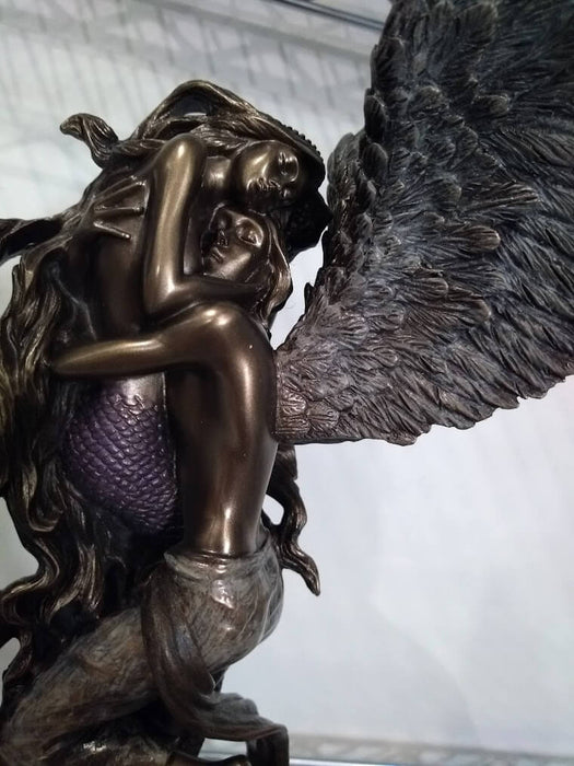 Closeup of the faces of the female mermaid and male angel embracing